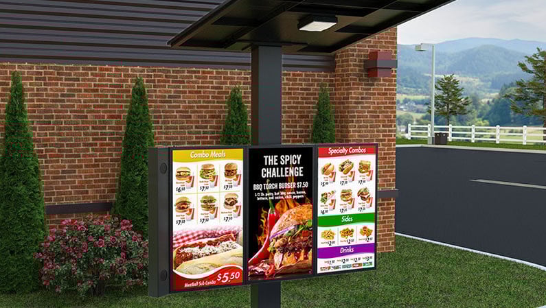 A 3 panel Revolution digital menu board with a side mounted speaker and flat canopy